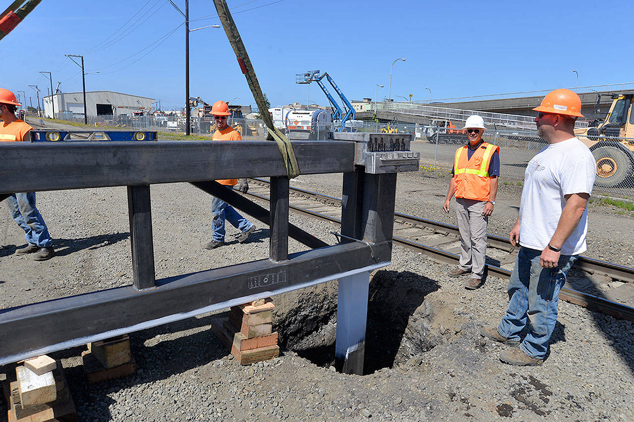 Louis Krauss | The Daily World                                Construction workers install a gate between the railroad tracks and a fence to prevent vehicle access to the Chehalis riverfront property where numerous homeless people live. This shot is facing west, with the Rognlins warehouse in the background.