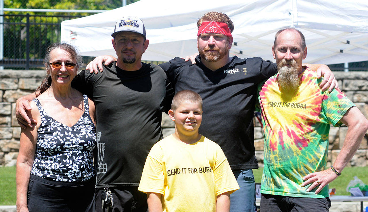 From left: Women’s champion Rhonda Snyder, first-place winner Jeremy Formemny, youth champion Tommy Floch, second-place finisher Orion Desilets and Bill Mullikin stand together at the conclusion of the Bubba Mullikin Memorial Disc Golf Tournament. (Hasani Grayson | The Daily World)