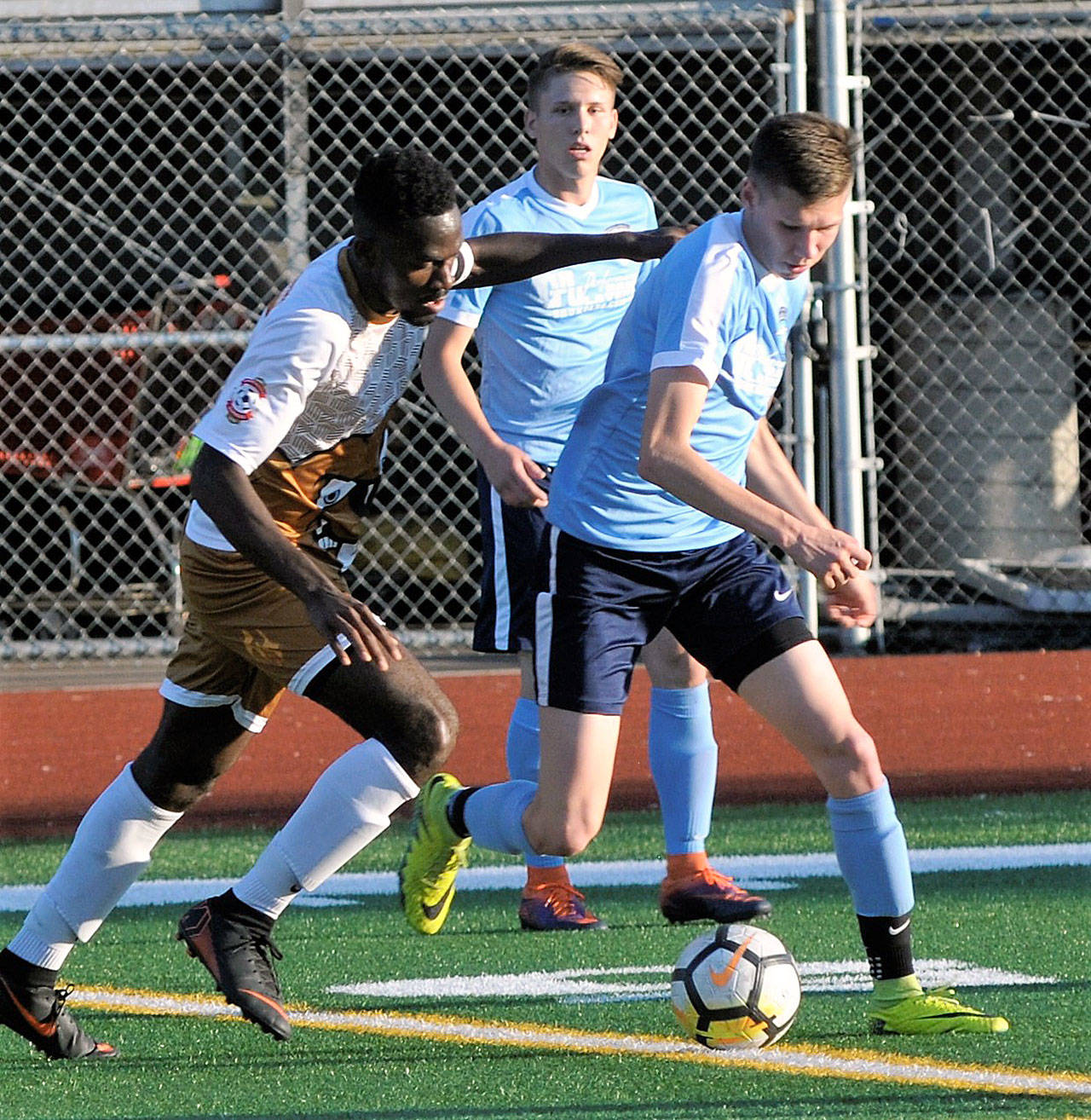 Grays Harbor’s Alex Pugadelarosa, right, looks for space around midfield while fending off a tackle against Lacy FC on Saturday. (Hasani Grayson | The Daily World)