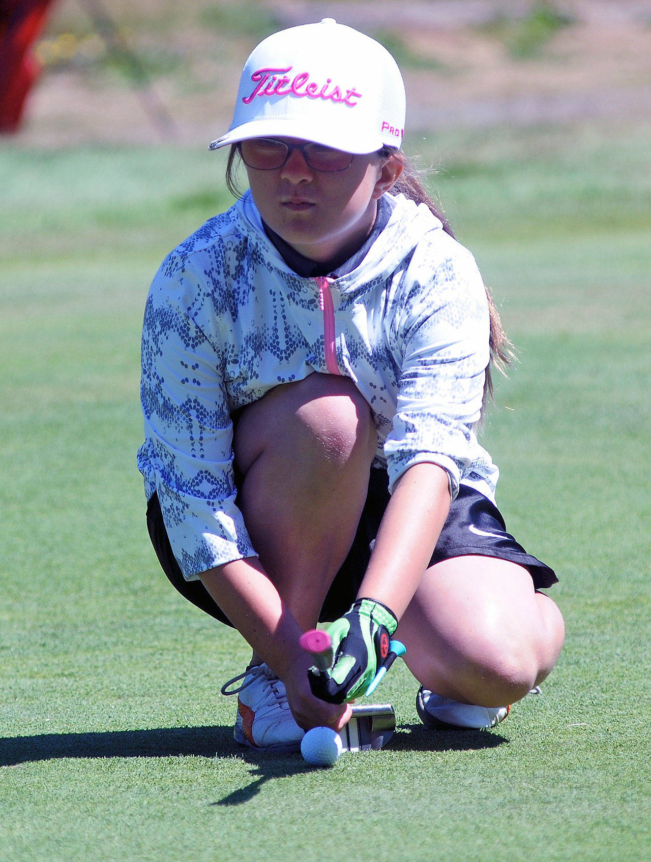 Haley Blancas lines up a putt at junior golf camp at the Highland Golf Course. (Hasani Grayson | The Daily World)