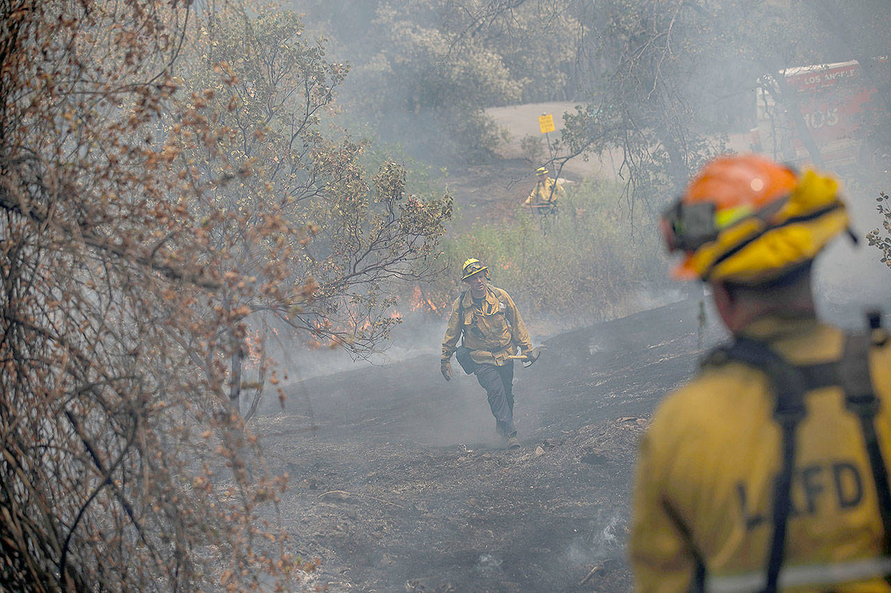 Firefighters from Los Angeles help stop the spread of a fire near homes in Redding, Calif., on Sunday. (Marcus Yam/Los Angeles Times)