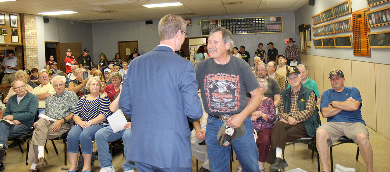 Rep. Derek Kilmer, back to camera, presented 63 pins to Vietnam War veterans and their family members during a ceremony to honor Vietnam vets Wednesday, Aug. 22, 2018, in Elma. Photo by Michael Lang, The Vidette