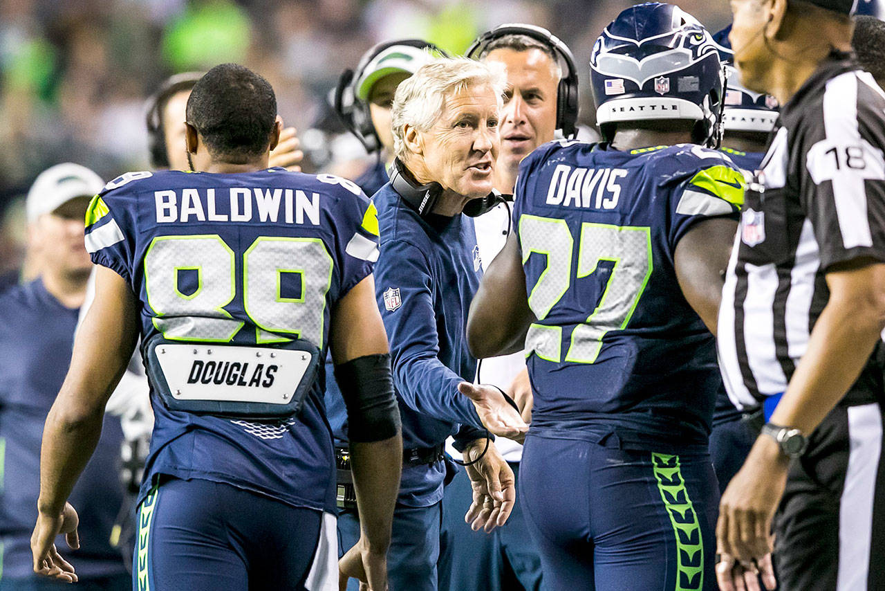 Seattle Seahawks head coach Pete Carroll congratulates running back Mike Davis on his second-quarter touchdown against the Oakland Raiders on Thursday. Carroll and his coaching staff will make their final cuts today ahead of Seattle’s season-opening game against the Denver Broncos on Sunday, Sept. 9. (Bettina Hansen/Seattle Times/TNS)