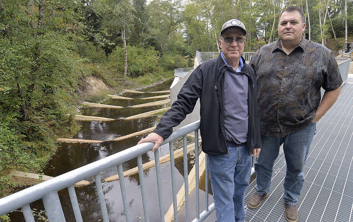 DAN HAMMOCK | THE DAILY WORLD                                Cosmopolis mayor Frank Chestnut (left) and city administrator Darrin Raines stand atop the walkway along the new Mill Creek Dam. Behind them is the fish ladder constructed to allow the return of steelhead and chum and coho salmon.