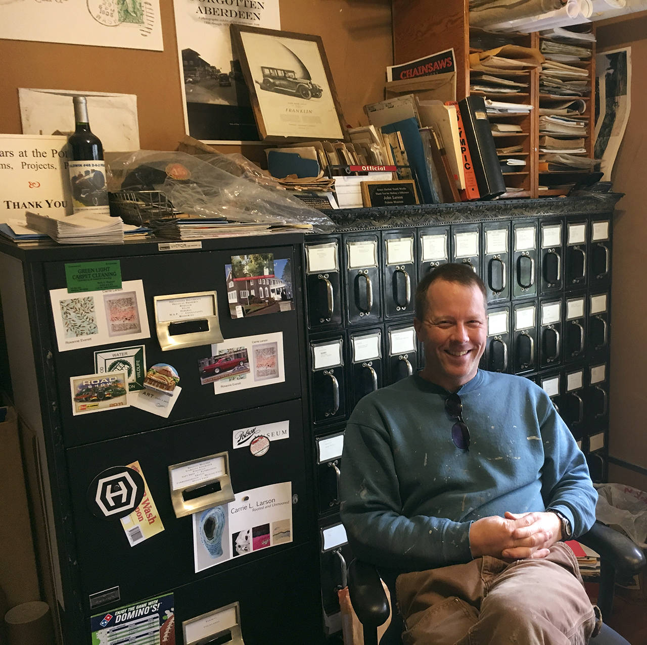 (Kat Bryant | Grays Harbor News Group) Polson Museum director John Larson (who describes his office as an “explosion”) takes a break from his work on the adjacent Hubble House, where he’s leading a full restoration for museum use.