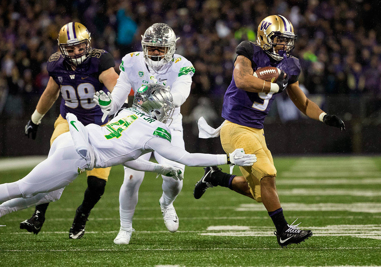 Washington running back Myles Gaskin, right, cuts to his left and leaves Oregon defender Thomas Graham Jr. behind, scoring on a 34-yard run in the second quarter at Husky Stadium in Seattle on Saturday, Nov. 4, 2017. (Dean Rutz/Seattle Times/TNS)