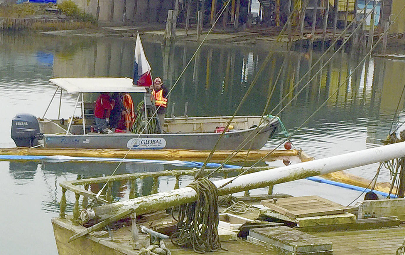 PHOTO COURTESY OF DEPARTMENT OF ECOLOGY                                Contract divers prepare to enter the Hoquiam River at the site where two vessels sank Wednesday to assess options for removing the diesel fuel leaking from one or both of the boats Friday morning.