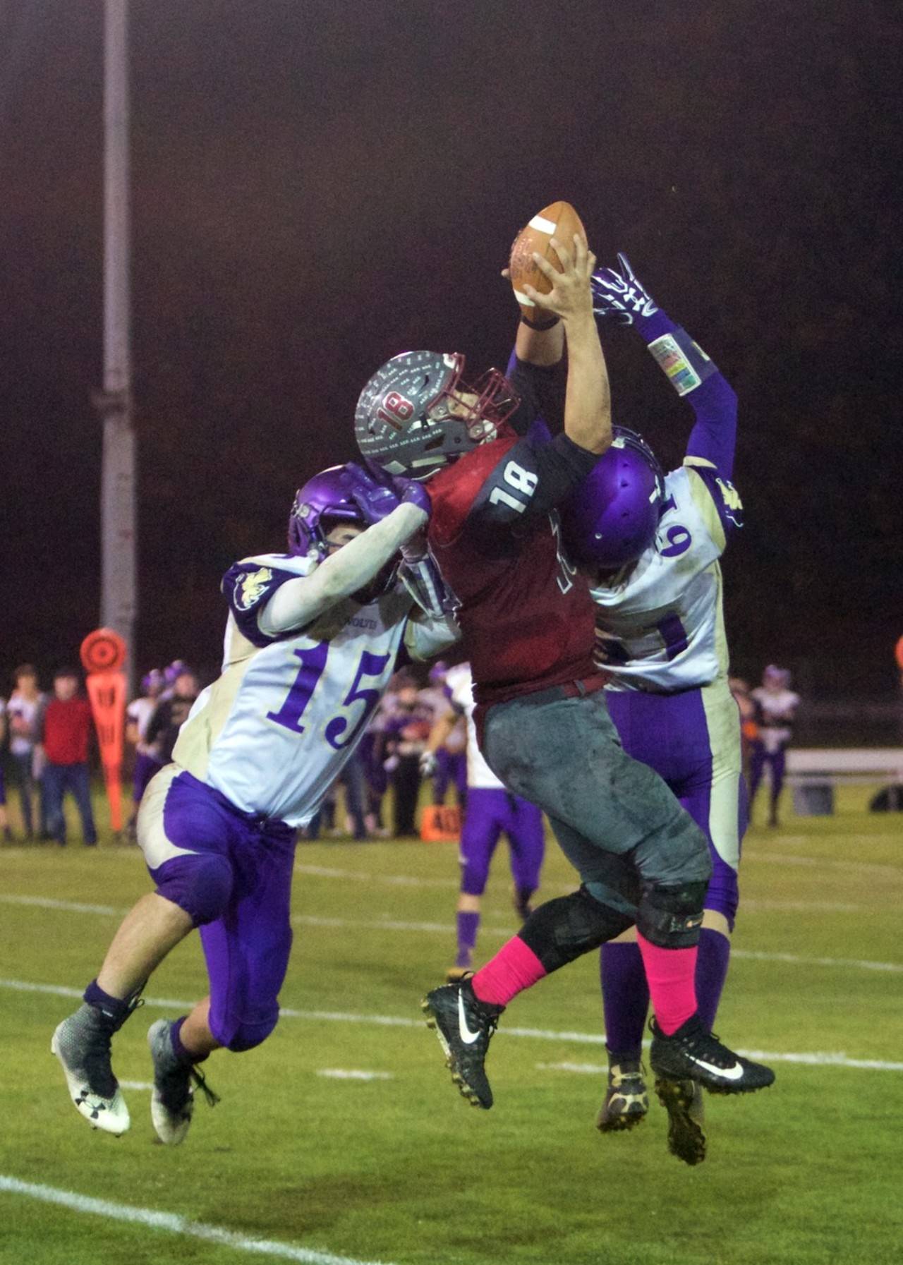 Hoquiam’s Payton Quintanilla rises to make a play on the ball against Sequim’s Taig Wiker (15) and Isaiah Cowan (61) on Friday at Olympic Stadium. (Photo by Patti Reynvaan)