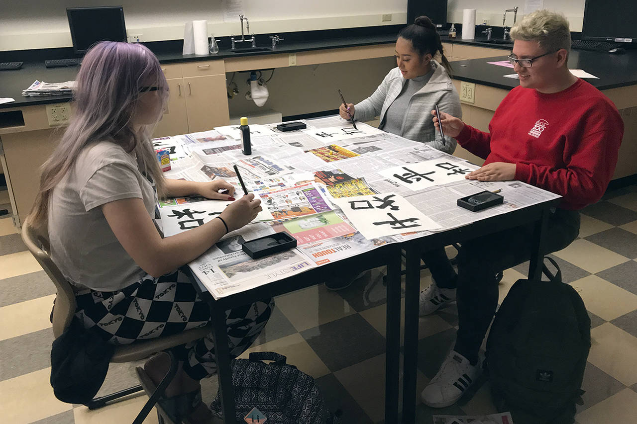 (Courtesy photo) Clockwise from left, students Anika Gramson, Mailee Touch and Ethan Watkins practice Japanese calligraphy.