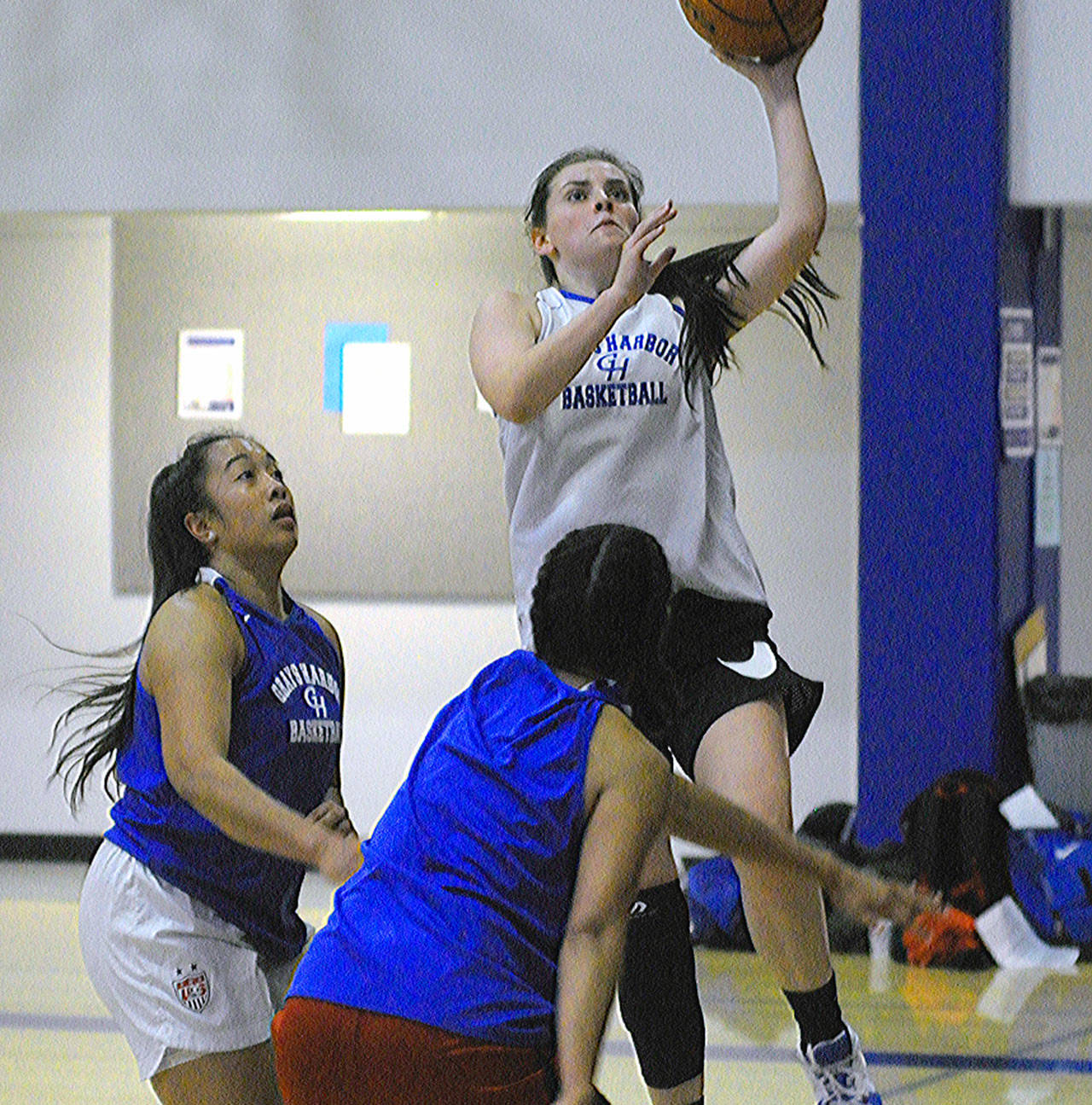 Grays Harbor’s Keeley Teel hits a layup in practice while defended by Tedra Tovia, left, and Isabel Hernandez. (Hasani Grayson | Grays Harbor News Group)