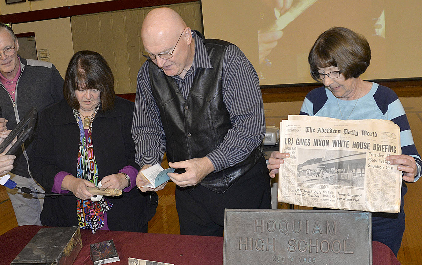 DAN HAMMOCK | GRAYS HARBOR NEWS GROUP                                Members of the Hoquiam High School Class of 1969 open a time capsule Friday that was placed behind the cornerstone of the student center, where it had been since the school was dedicated exactly 50 years ago to the day. At left is Denise Burke, at center is former Hoquiam City Councilman John Pellegrini.