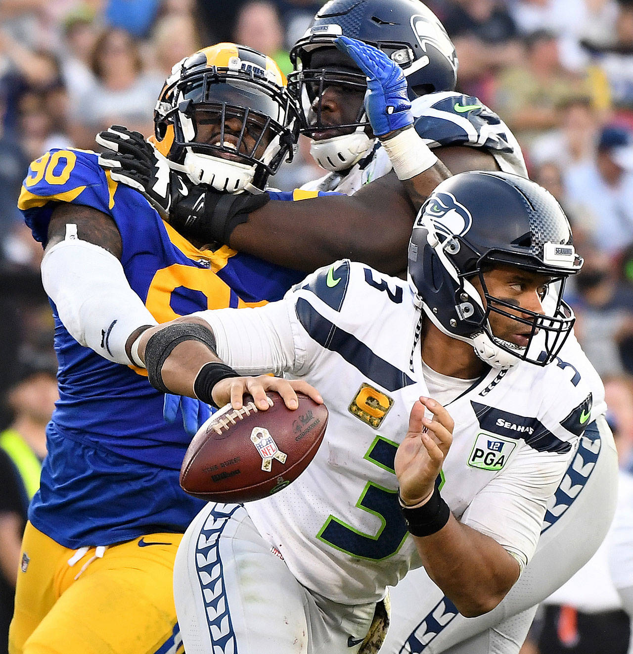 Seattle Seahawks quarterback Russell Wilson scrambles away from Los Angeles Rams defensive lineman Michael Brockers in the fourth quarter on Sunday, Nov. 11, 2018 at the Coliseum in Los Angeles, Calif. (Wally Skalij/Los Angeles Times/TNS)