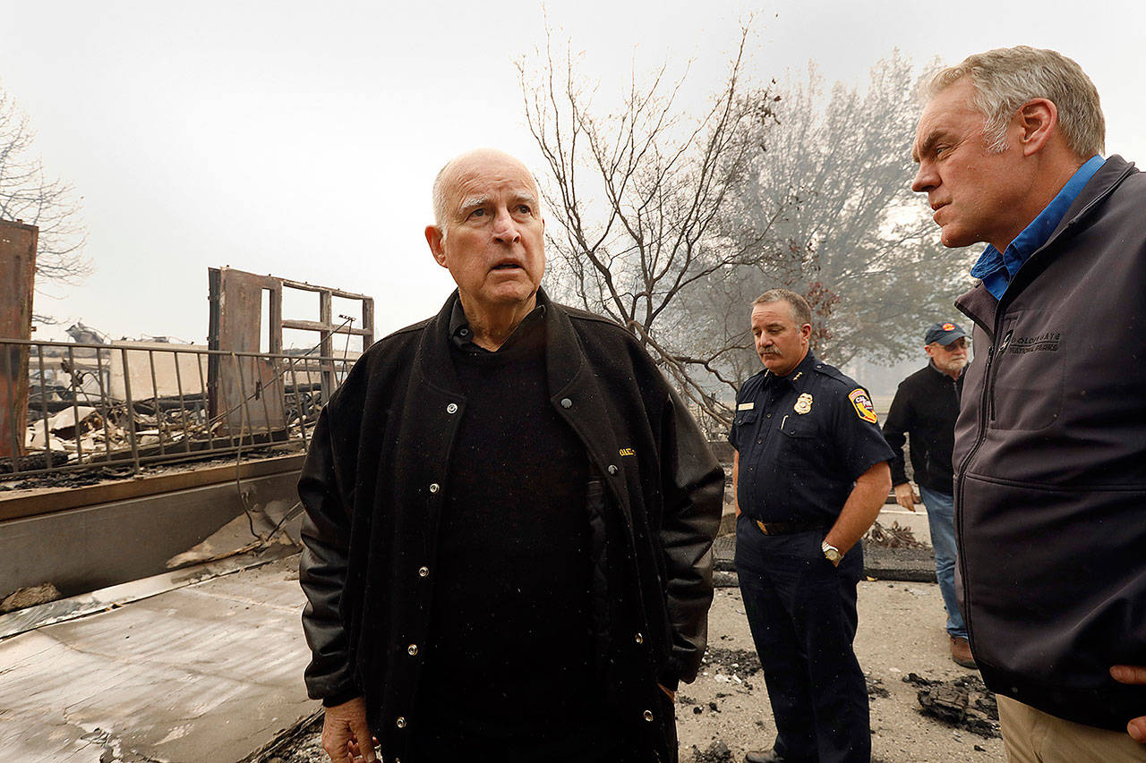 California Gov. Jerry Brown, left, tours downtown Paradise, Calif., on Nov. 14 with Secretary of the Interior Ryan Zinke, right, as they view the damage done to Paradise Elementary School. (Carolyn Cole/Los Angeles Times)