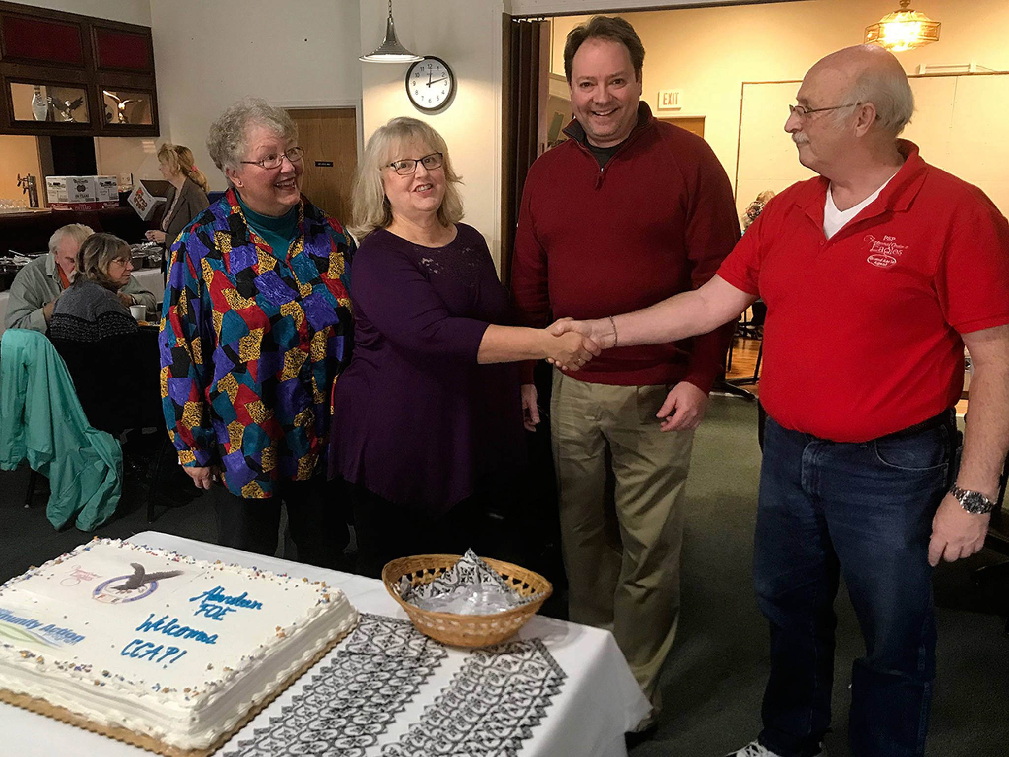 Louis Krauss | Grays Harbor News Group                                Lonnie Wild (left), CCAP Senior Nutrition Coordinator Vicky Johnson, Jason Hoseney from CCAP and Mike Simonds from the Aberdeen Eagles Club pose next to a cake welcoming CCAP after they purchased the old Eagles building.