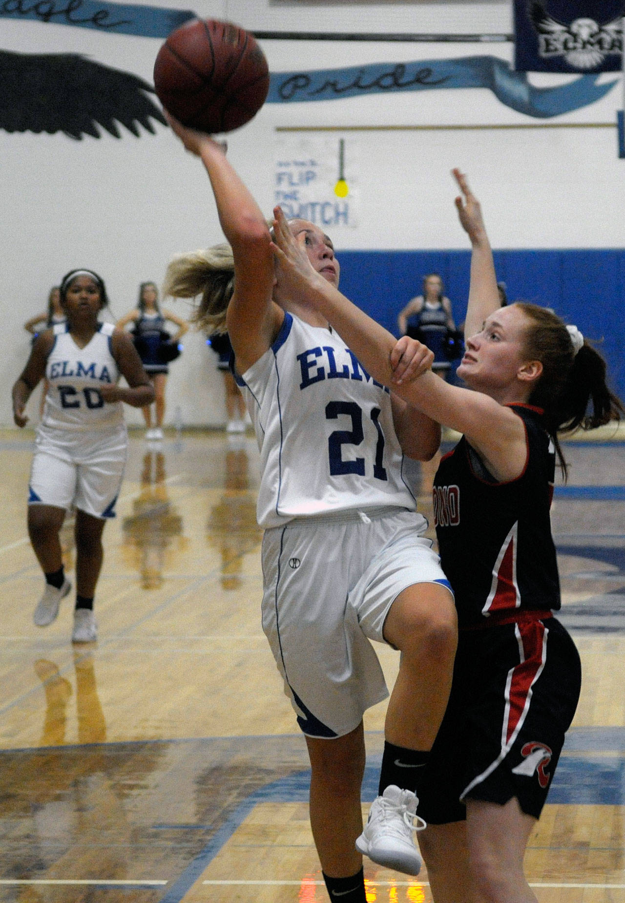 Elma’s Kayli Jonhnson finishes the layup while defended by Raymond’s Izzy Silvernail in the first quarter on Tuesday night. (Hasani Grayson | Grays Harbor News Group)