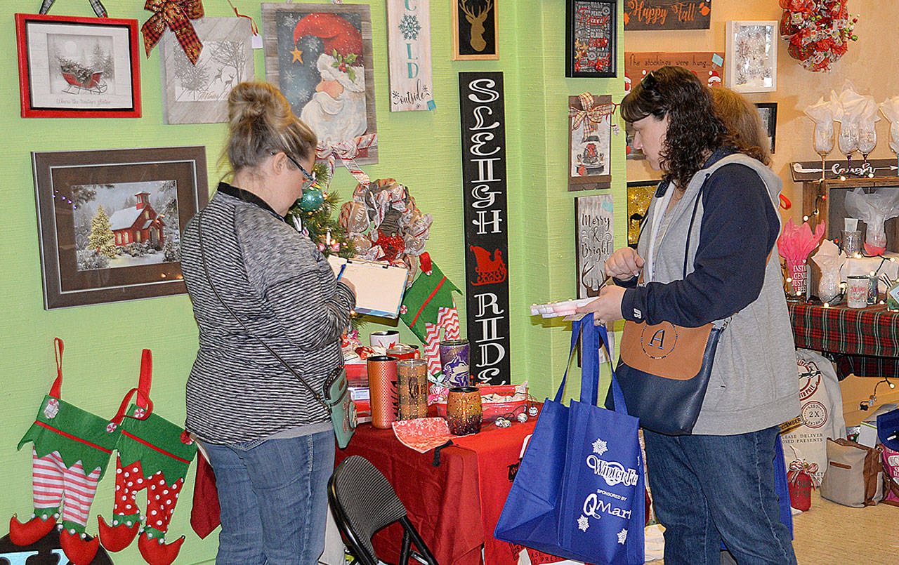 DAN HAMMOCK | GRAYS HARBOR NEWS GROUP                                Shoppers check out a booth of handcrafted holiday decorations at the Aberdeen Winterfest holiday market Saturday morning. The market at 117 West Wishkah featured about 30 vendors and there were free drawings shoppers could enter until the market closed at 3 p.m.