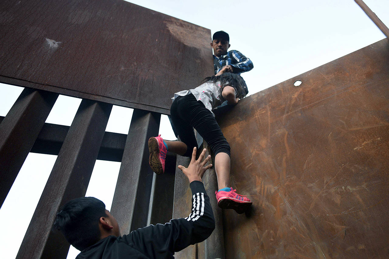 Dozens of migrants, mostly women and children have squeezed through the fence on the beach or climbed over the wall at low points along the Tijuana-San Diego border at La Playa. Most knew they would be immediately detained, but preferred that to the limbo of living indefinitely in shelters in Mexico. (Carol Guzy | ZUMA Wire)