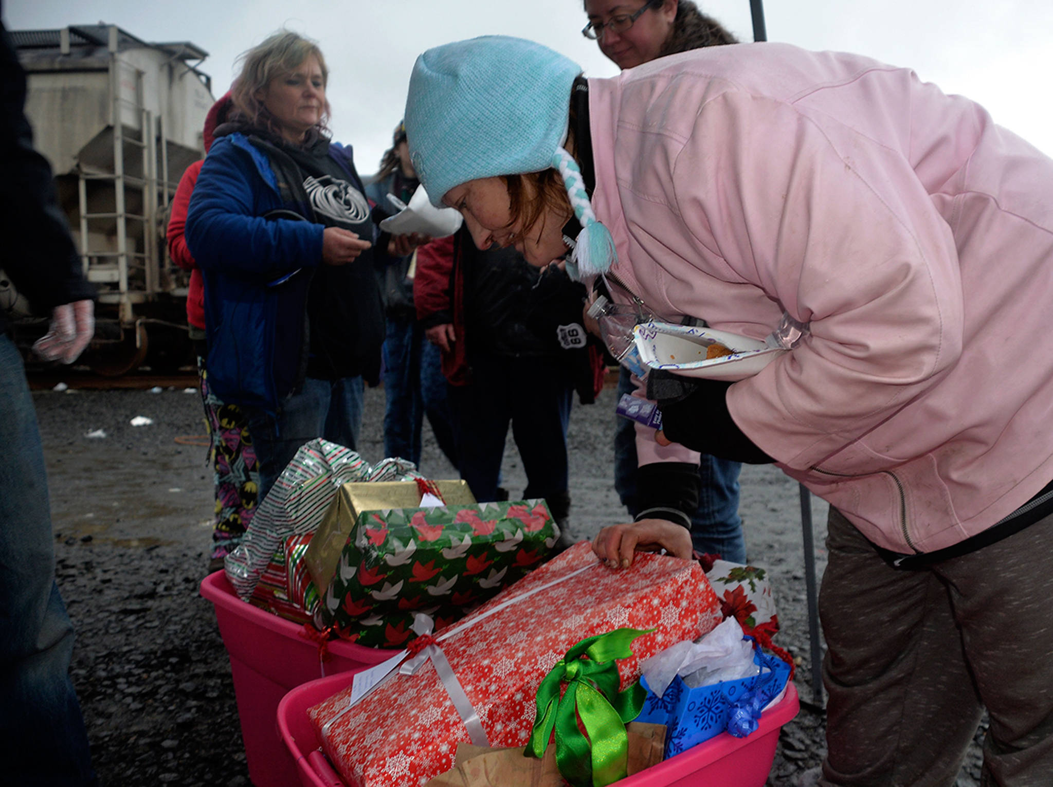 (Louis Krauss | Grays Harbor News Group) Mandy Nottingham peruses wrapped presents given away at Aberdeens riverfront homeless camp on Wednesday.