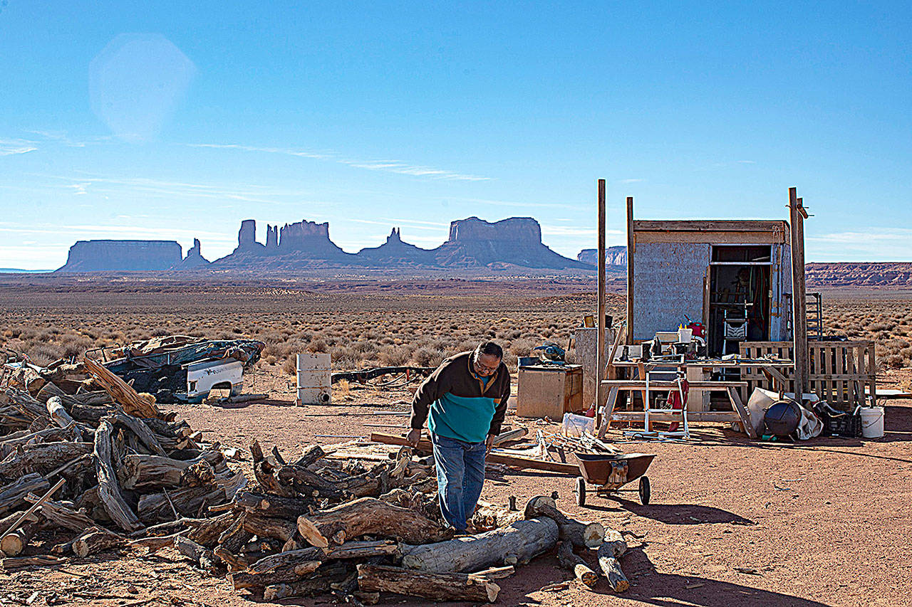Jonah Yellowman looks over firewood, gathered from Cedar Mesa, at his home on the edge of Monument Valley, Utah. (Brian van der Brug/Los Angeles Times)