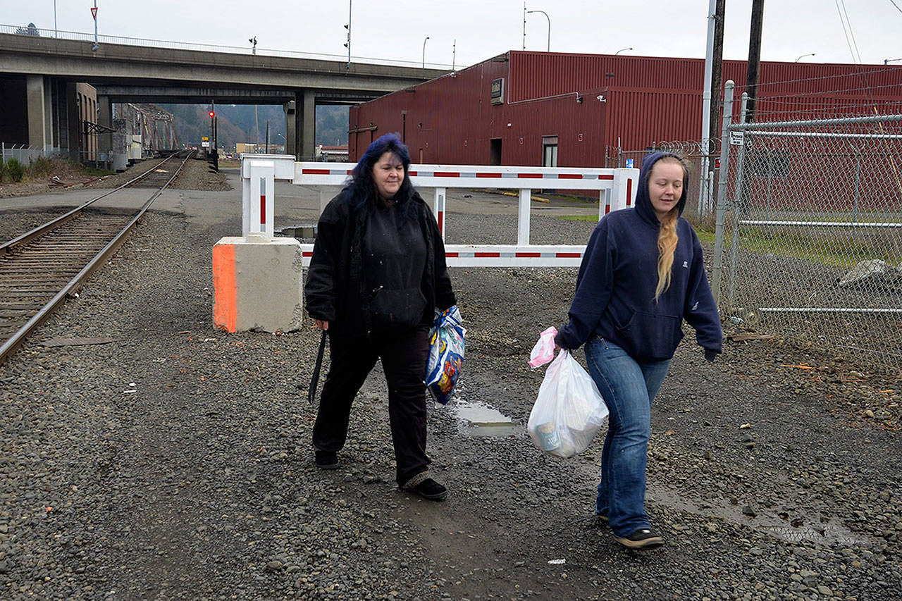 (Louis Krauss | Grays Harbor News Group) Tracy Clayton, left, and her daughter Skye Clayton deliver food to homeless people at Aberdeens riverfront homeless camp.