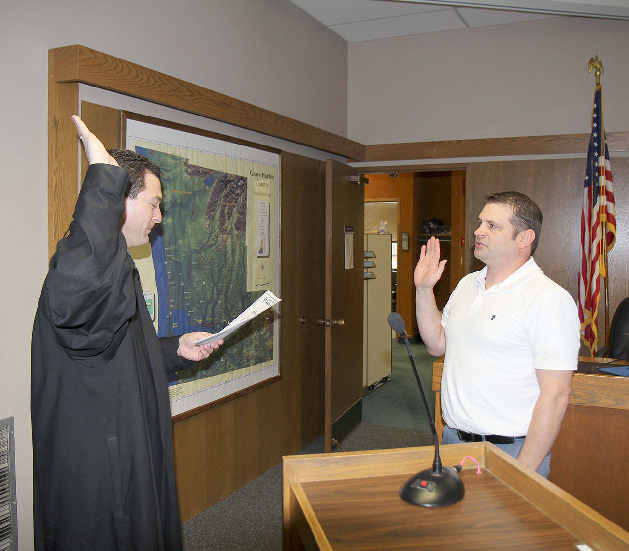 Michael Lang | Grays Harbor News Group                                Grays Harbor County Assessor Dan Lindgren (right) is sworn in to office Jan. 2 by Judge David Mistachkin in County Commission chambers in Montesano.