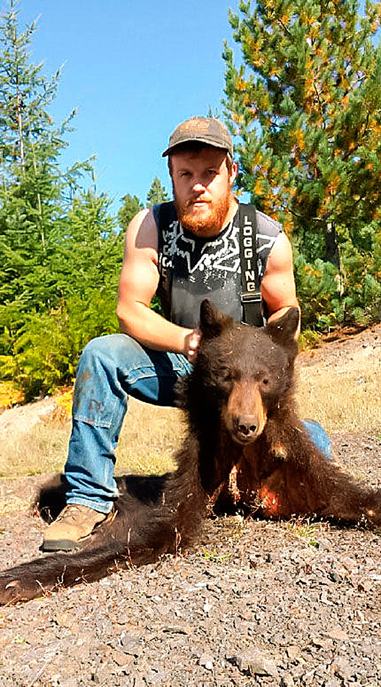 William Haynes poses with the carcass of a poached bear (Courtesy WDFW)