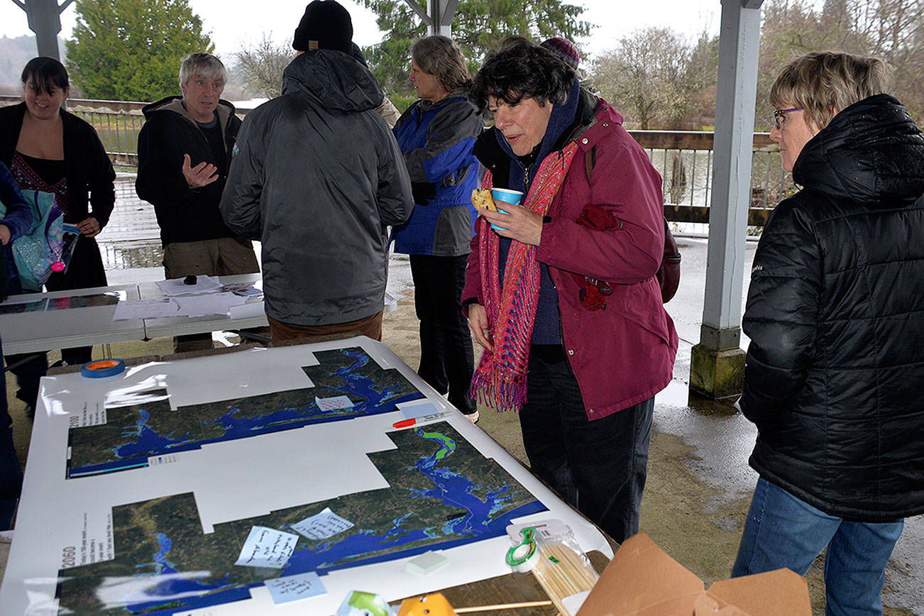 Louis Krauss | Grays Harbor News Group                                Ruth Garrett, in pink jacket, checks out a map of potential flooding scenarios in Grays Harbor and Pacific counties based on sea level rise in 2060 and 2100.