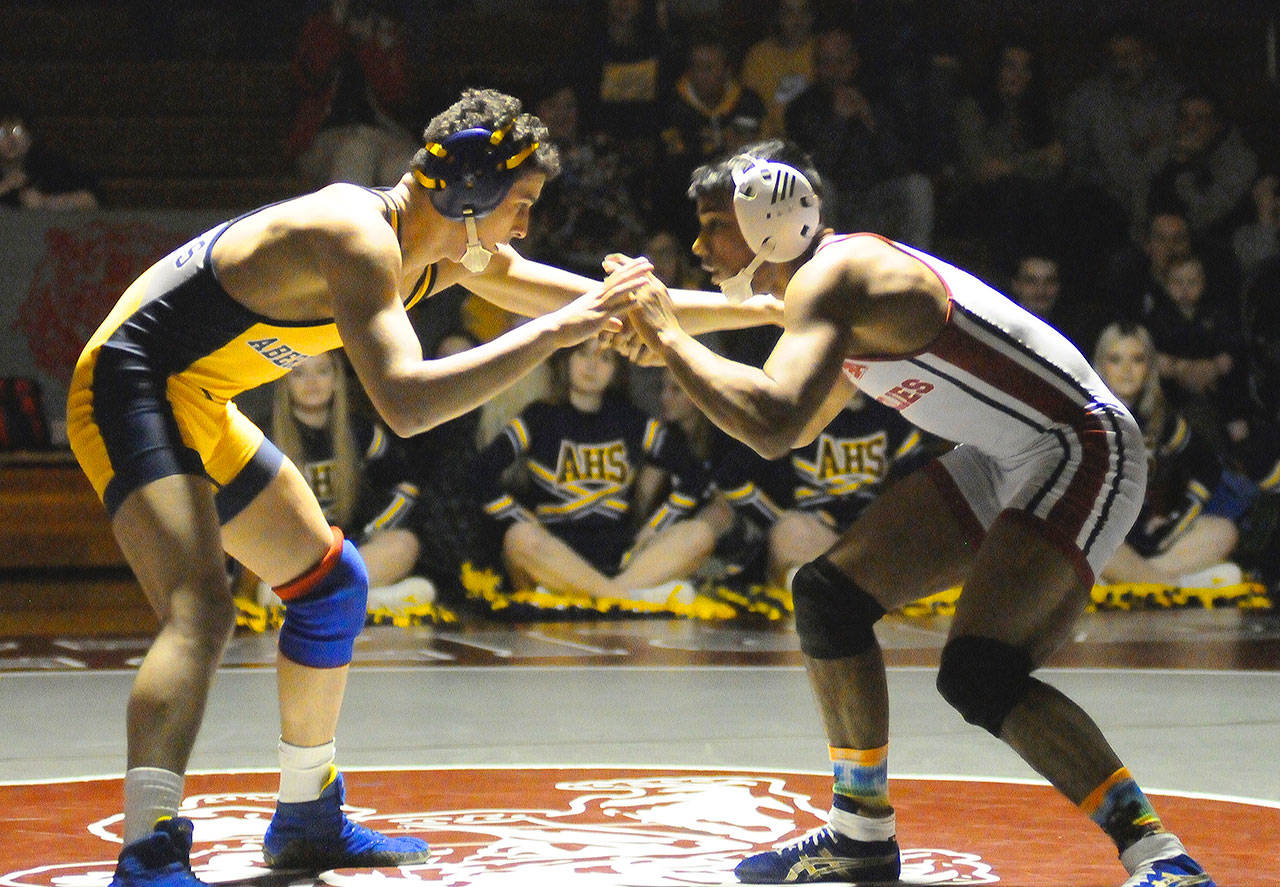 Abedeen’s Ashton Goings, left, locks hands with Hoquiam’s Alex Houbregs in the first round of their 132-pound match on Thursday. (Hasani Grayson | Grays Harbor News Group)