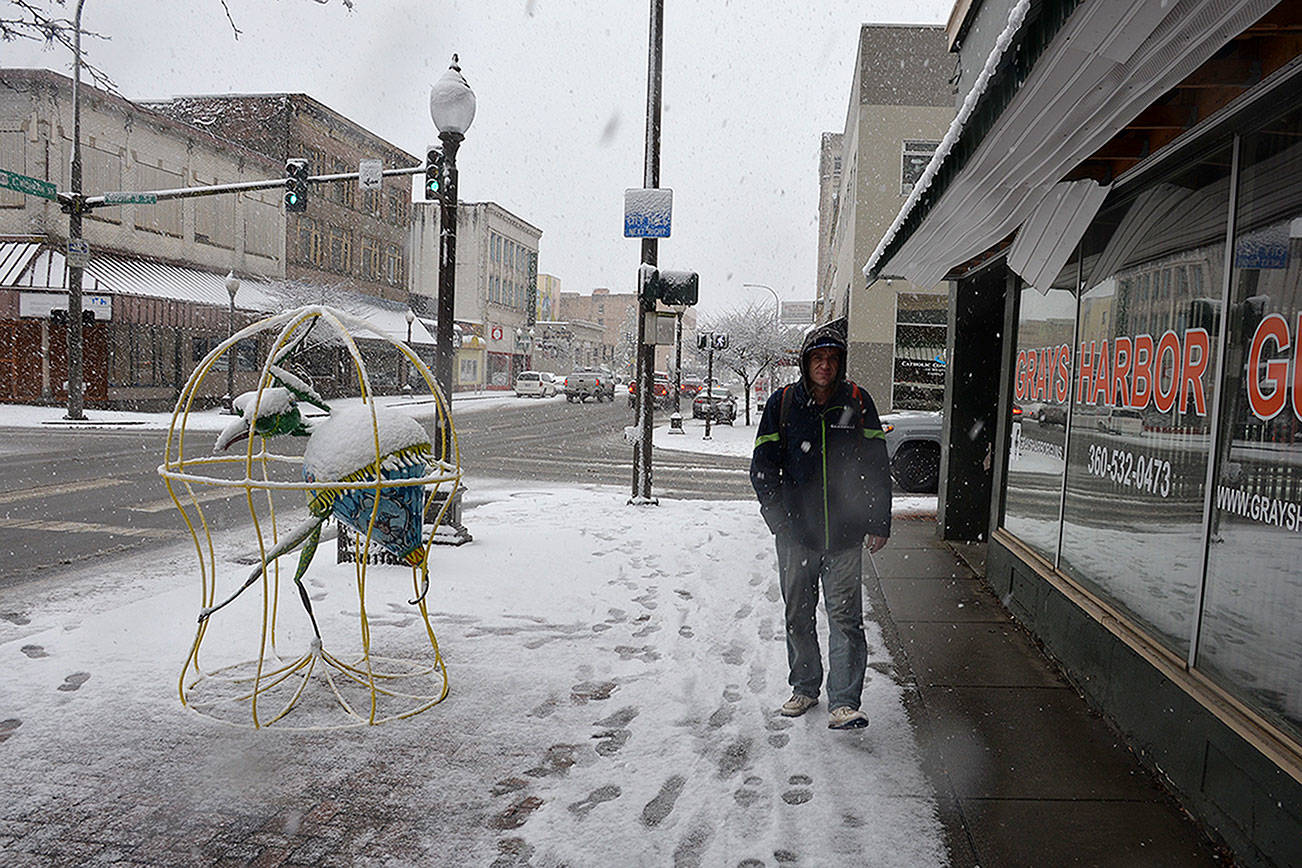 (Louis Krauss | Grays Harbor News Group) Chad Otto walks through downtown Aberdeen in the snow.