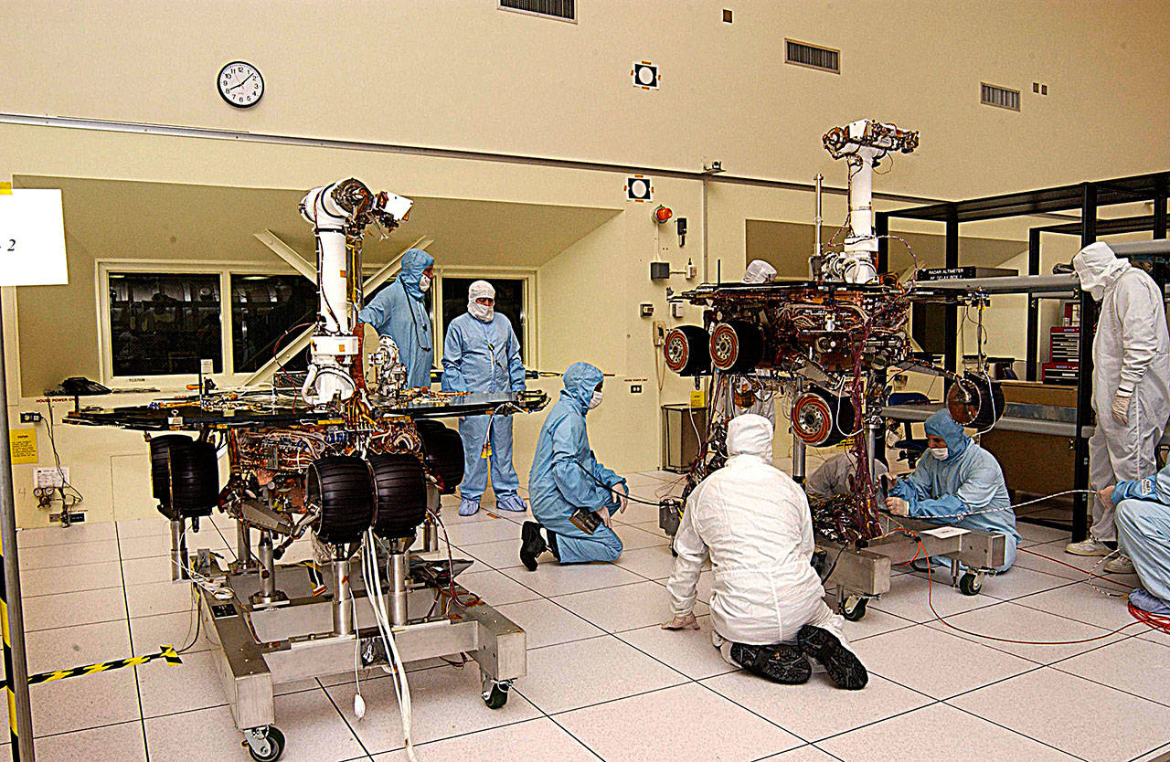 JPL engineers make adjustments to Spirit. At left is its twin, Opportunity. (Jet Propulsion Laboratory)