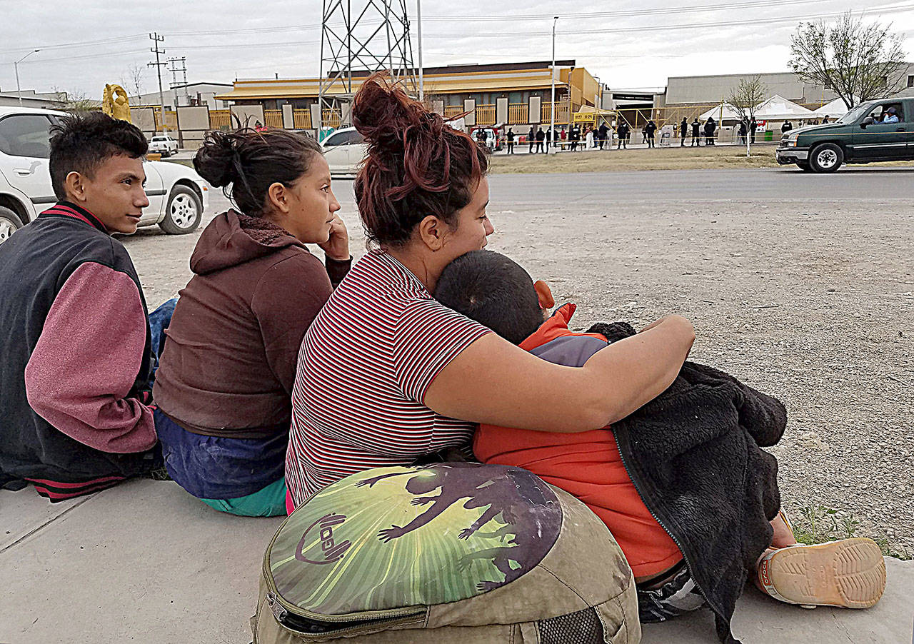 Merlin Linares Rodriguez, 23, center, a Salvadoran migrant staying at the Piedras Negras shelter Monday with her 7-year-old son Jose Garcia Linares, right, waits across the street with siblings Cristiano Maradiaga Herrera, 15, and Irisujapa Maradiaga Herrera, 14. (Molly Hennessy-Fiske/Los Angeles Times)