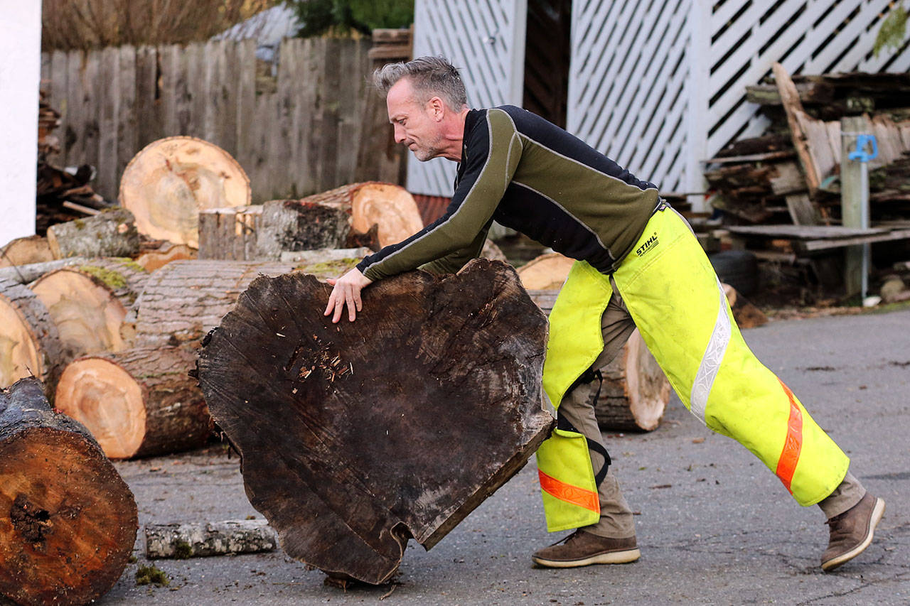 Shane McDaniel moves wood at his home in Lake Stevens in January. (Kevin Clark / The Herald)