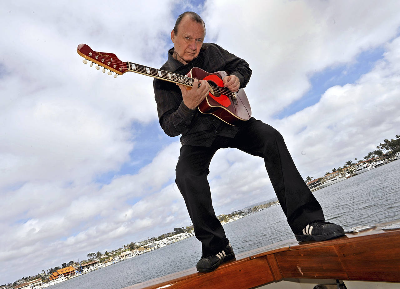 photos by Michael Goulding | Orange County Register                                 Legendary surf guitarist Dick Dale strums his self-designed acoustic guitar standing on the rail of his yacht in Newport Harbor, California, in 2009.