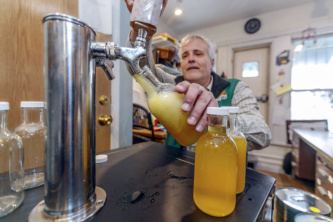 Weavers Way Co-op store manager Rick Spalek fills 16-ounce bottles with GTS Cannabliss kombucha, which contains CBD. (Michael Bryant | The Philadelphia Inquirer)