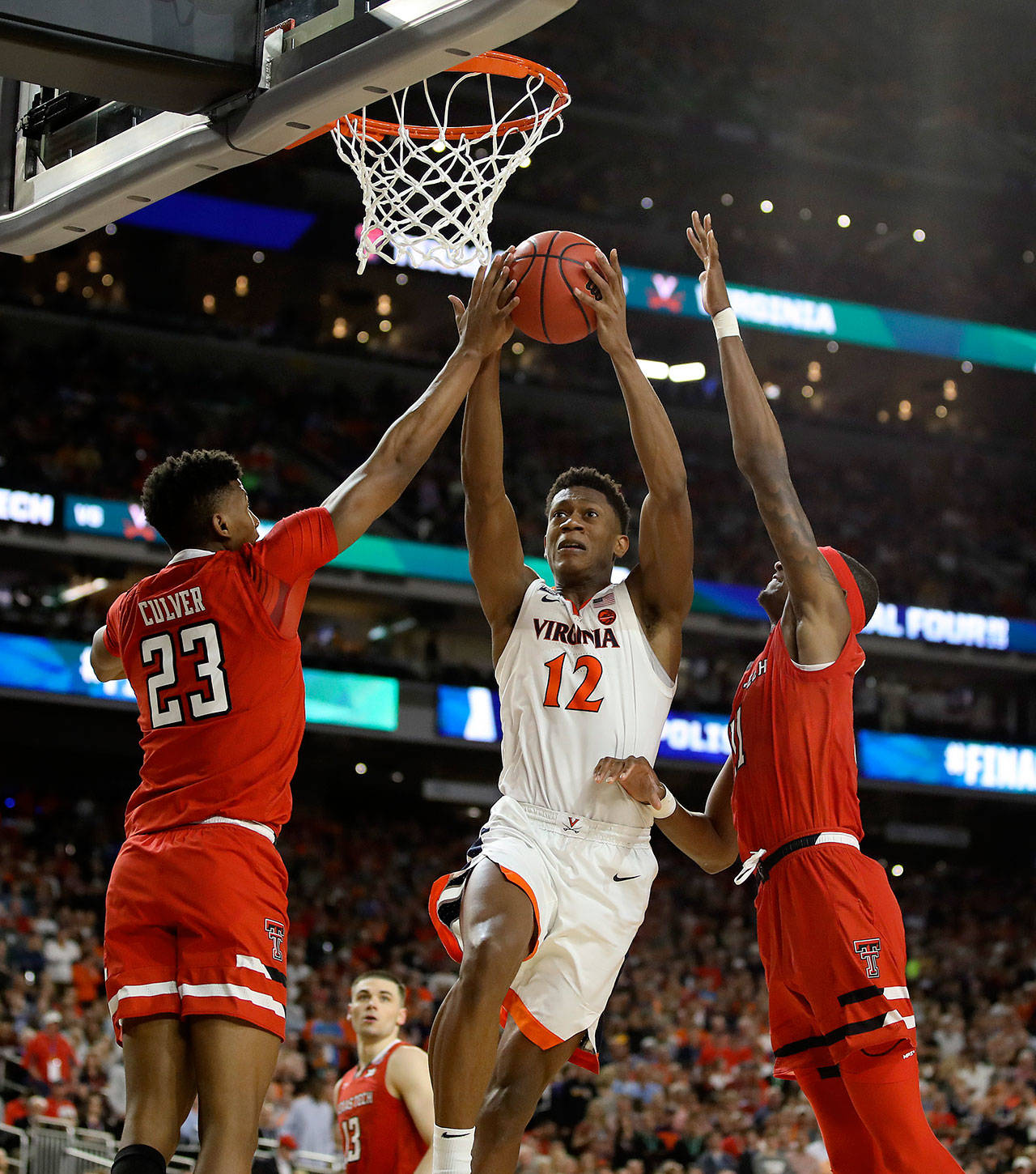 Virginia Cavaliers guard De’Andre Hunter (12) goes up for a shot between the defense of Texas Tech’s Jarrett Culver (23) and Tariq Owens (11) during the second half of the NCAA Championship Game on April 8, 2019 at U.S. Bank Stadium in Minneapolis, Minn. (Brian Peterson/Minneapolis Star Tribune/TNS)