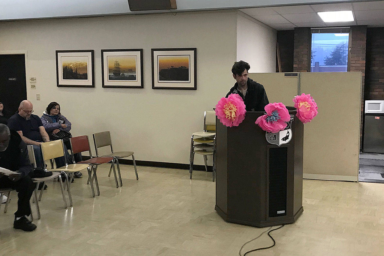 (Louis Krauss | Grays Harbor News Group) Christopher Emerson, who lives at the riverfront, gives a public comment at the Aberdeen City Council meeting. The flowers were attached as part of a resolution to recognize June 21 as Bloom Day.