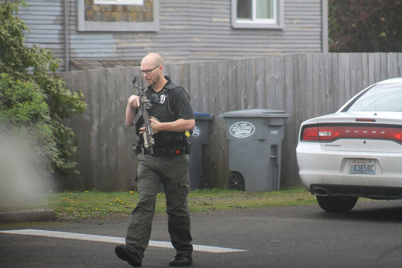 (Josh Jessen photo) An Aberdeen Police officer is armed with an assault rifle during the standoff Tuesday in Montesano.