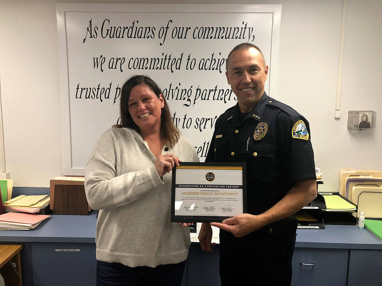 (Courtesy April Heikkila | Grays Harbor News Group) Sarah Oleachea, a member of the Harbor Strong coalition and an Aberdeen High School student parent, presents Aberdeen Police Chief Steve Shumate a certificate of appreciation for efforts to reduce unused prescription medications in Aberdeen.