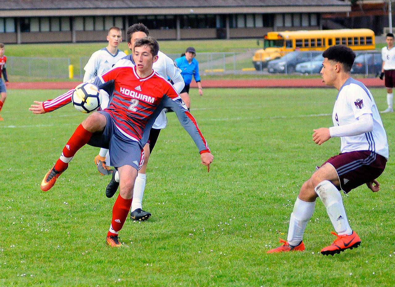Hoquiam forward Skyler Johnson (2) controls a bouncing ball while defended by Montesano’s Yemi Idowu in the second half on Friday. Johnson scored the first goal of the match in the Grizzlies’ 2-0 win over the Bulldogs. (Hasani Grayson | Grays Harbor News Group)