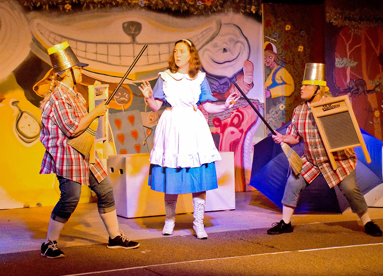 (Scott D. Johnston | Grays Harbor News Group) In a scene from the Stage West Community Theatre production of “Alice in Wonderland,” Alice (Joni Chism) finds herself in the middle as Tweedledee (Pamela Nygaard on right) and Tweedledum (Cai Hadfield) prepare for battle with brooms, buckets and washboards.