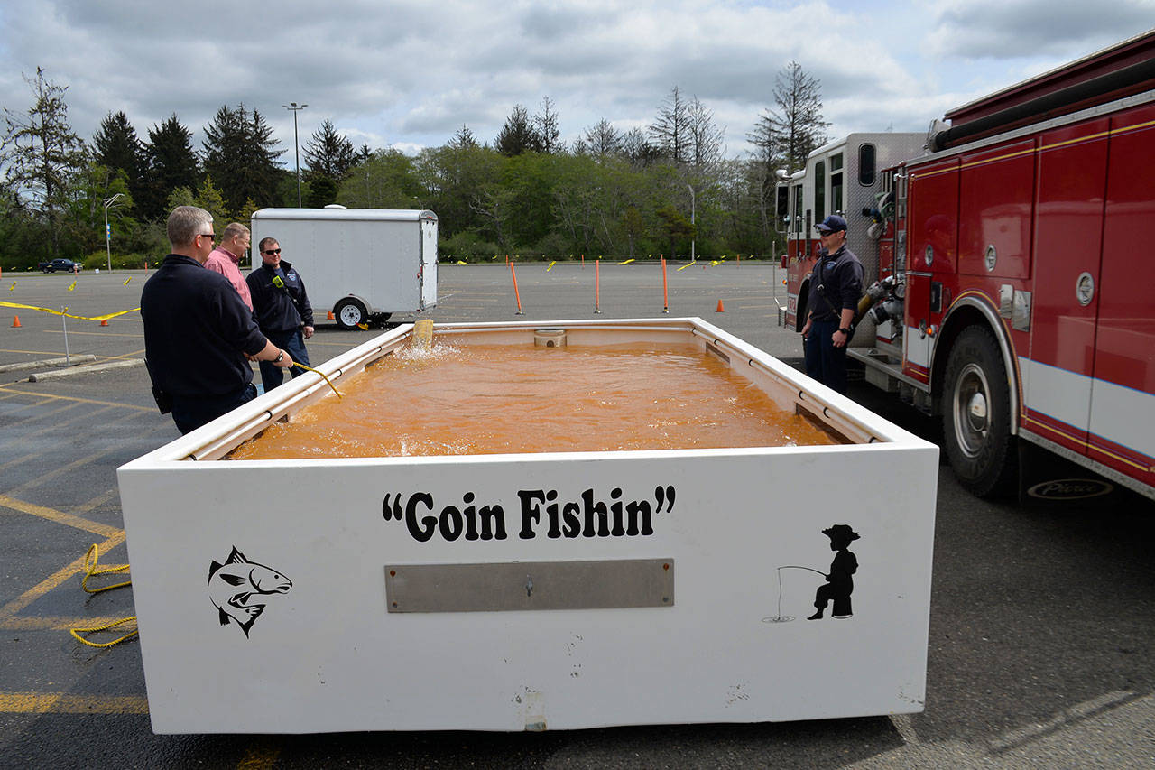 (Louis Krauss | Grays Harbor News Group) Members of the Aberdeen Fire Department fill up a tankard from the Washington State Department of Fish and Wildlife with water for this weekends Grays Harbor Outdoor Expo. Visitors can fish trout, brought from Lake Aberdeen, out of the tank for free during the expo. The tank has a self-filter system that will make the water cleaner, staff on hand said.