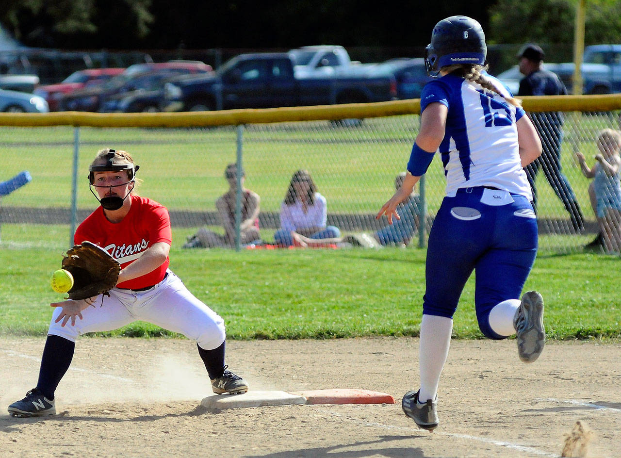 Pe Ell-Willapa Valley first basemen Kamryn Adkins stretches at first while Elma’s Olivia Cain races down the line on Thursday in Menlo. (Hasani Grayson | Grays Harbor News Group)
