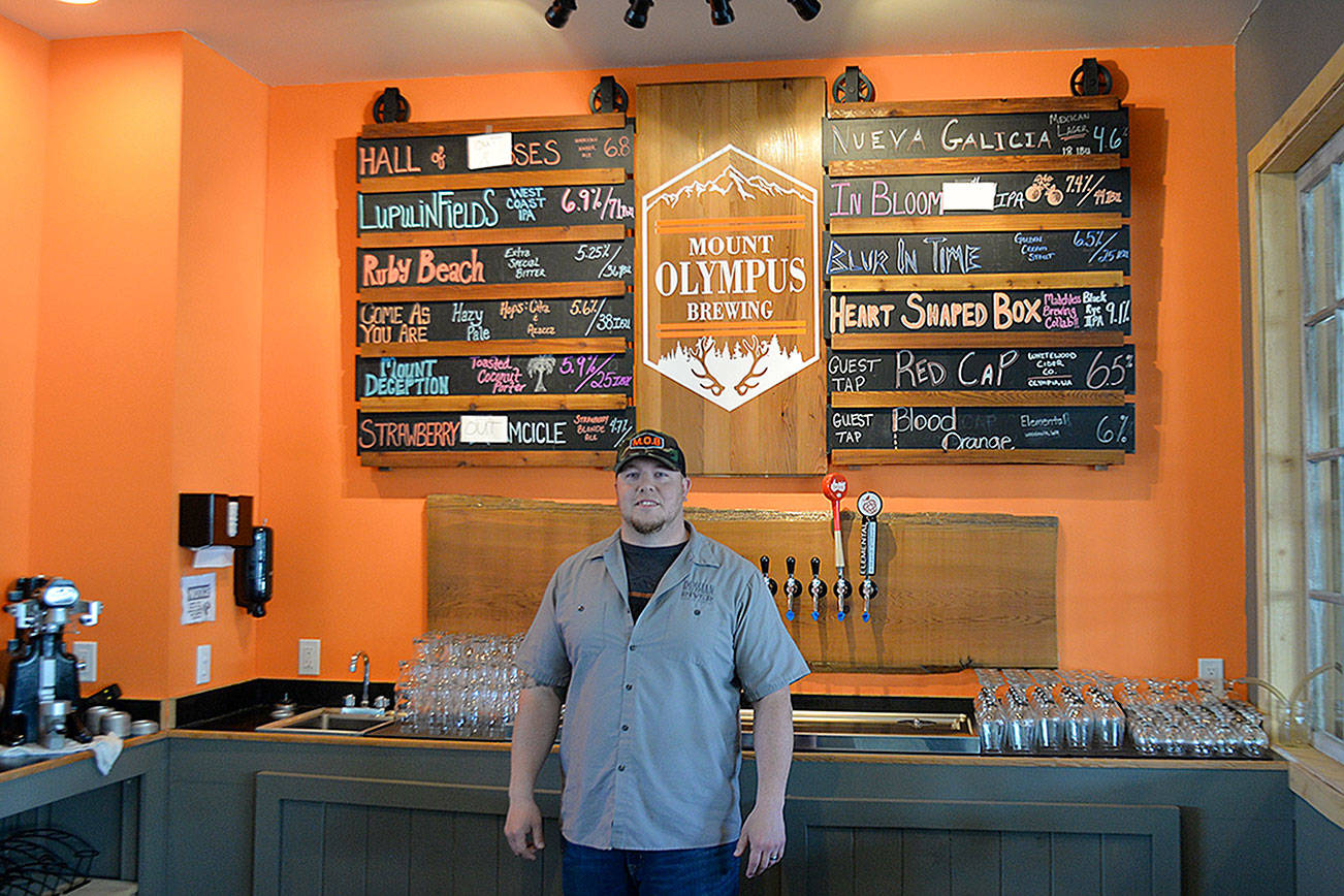 photos by Louis Krauss | Grays Harbor News Group                                Brewer Orlando Maldonado stands in front of the current beer list at Mount Olympus Brewing Company in Aberdeen.