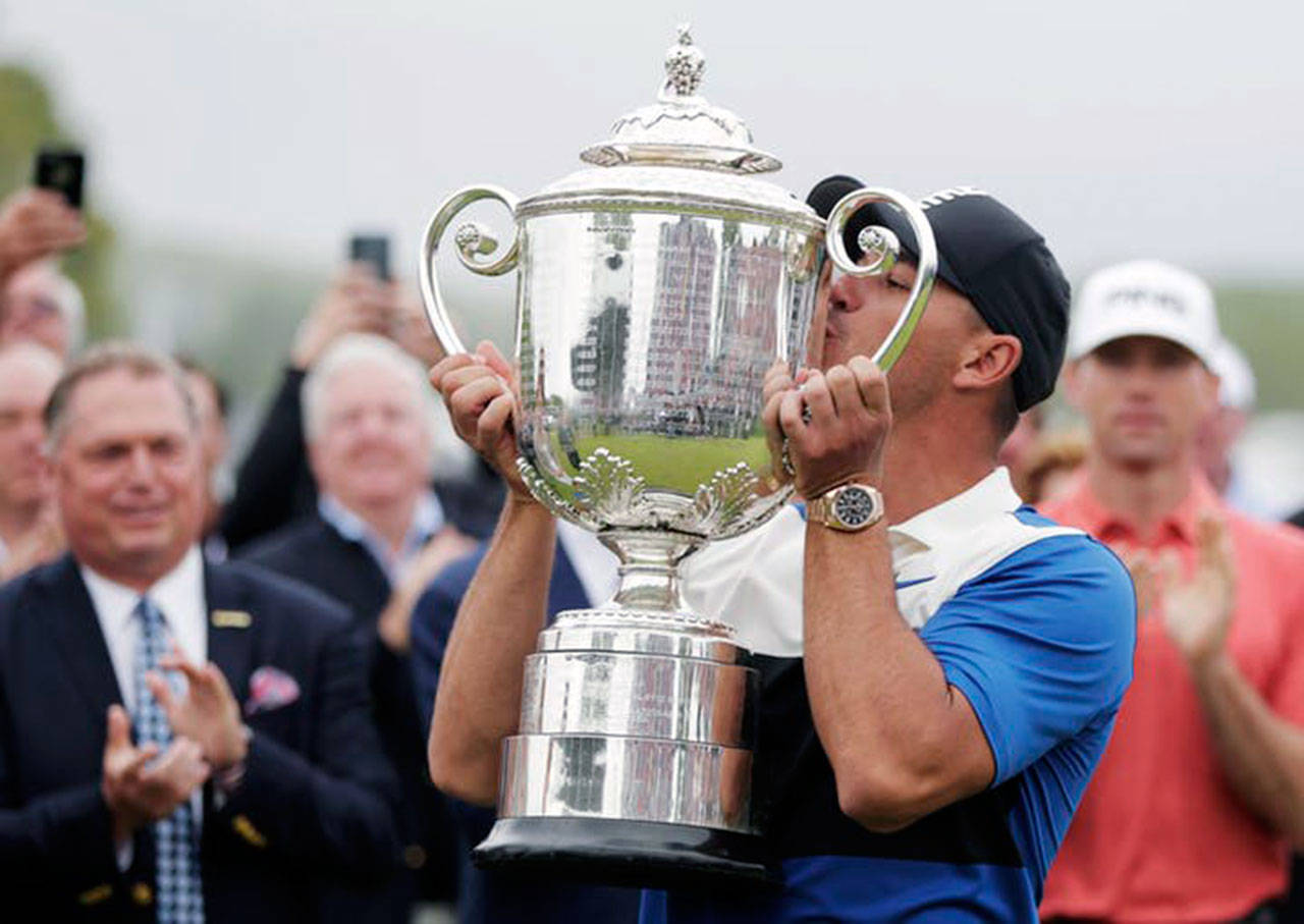 Brooks Koepka kissed the Wanamaker Trophy after repeating as winner of the PGA Championship on Sunday. He held off a late charge by Dustin Johnson for a two-shot victory. (TNS Wire Service)