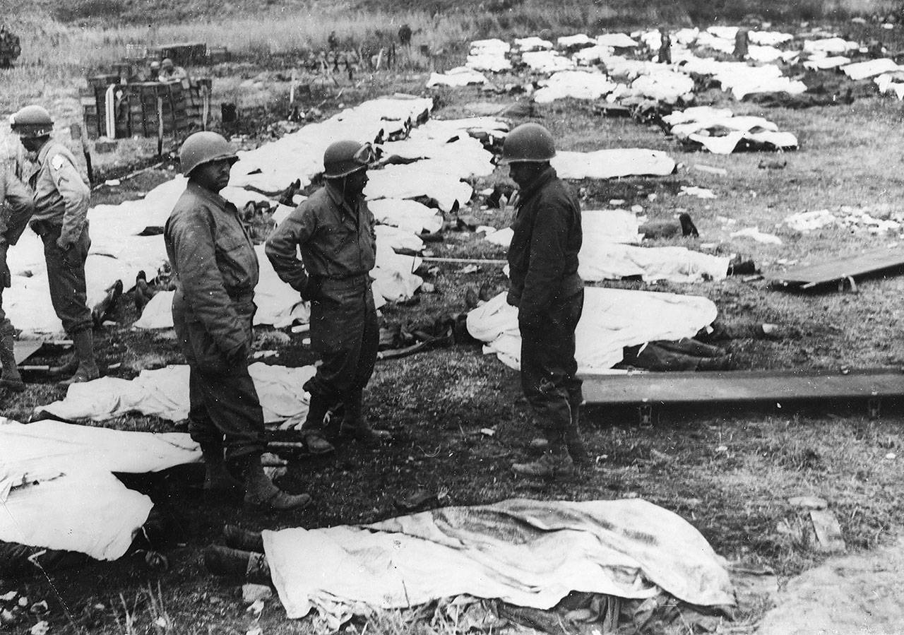 June 1944: Medical orderlies with the dead ready for burial in one of the first invasion graveyards in France. (Keystone/Hulton Archive/Getty Images)