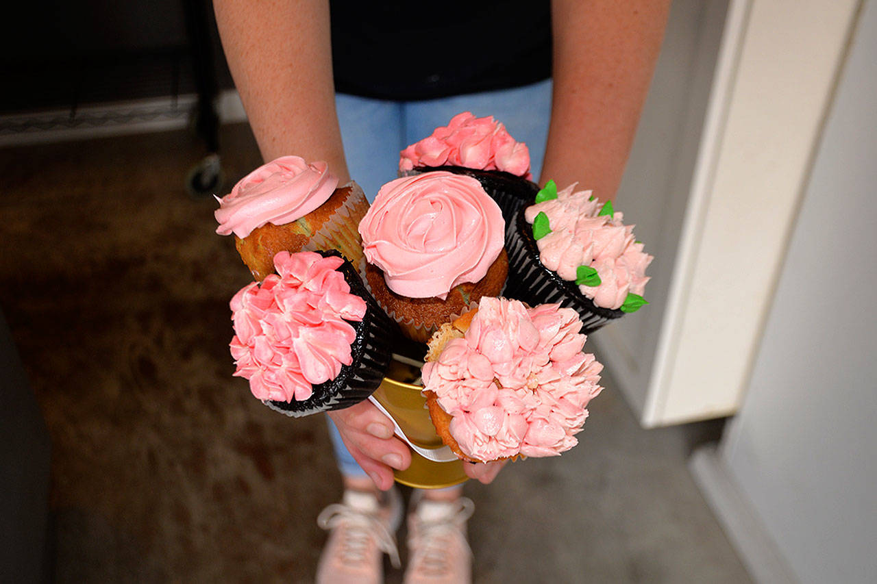 (Louis Krauss | Grays Harbor News Group) Cake Cakes owner Brittany Case holds up some pink cupcakes she made for this year’s Aberdeen Bloom Day.