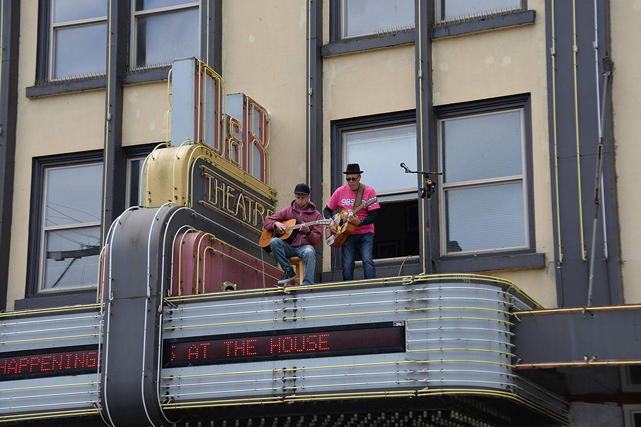 (Louis Krauss | Grays Harbor News Group) Alex Lebbert, left, from Westport, plays guitar with Wil Russoul above the D&R Theatre Friday as part of Bloom Day.
