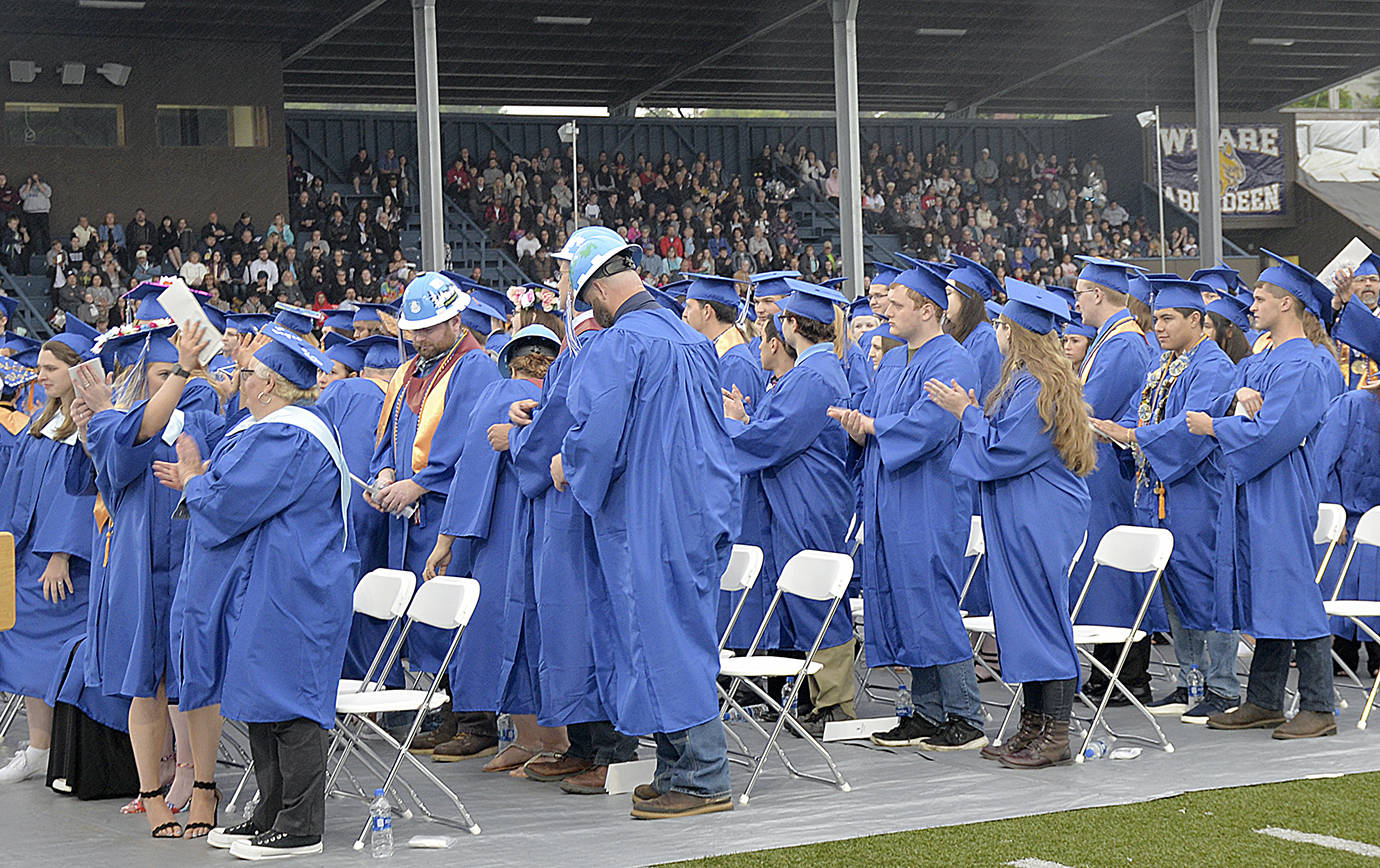 DAN HAMMOCK | GRAYS HARBOR NEWS GROUP                                Members of the 2019 Grays Harbor College graduating class applaud their supporters in the stands at Stewart Field during Friday’s commencement ceremony.