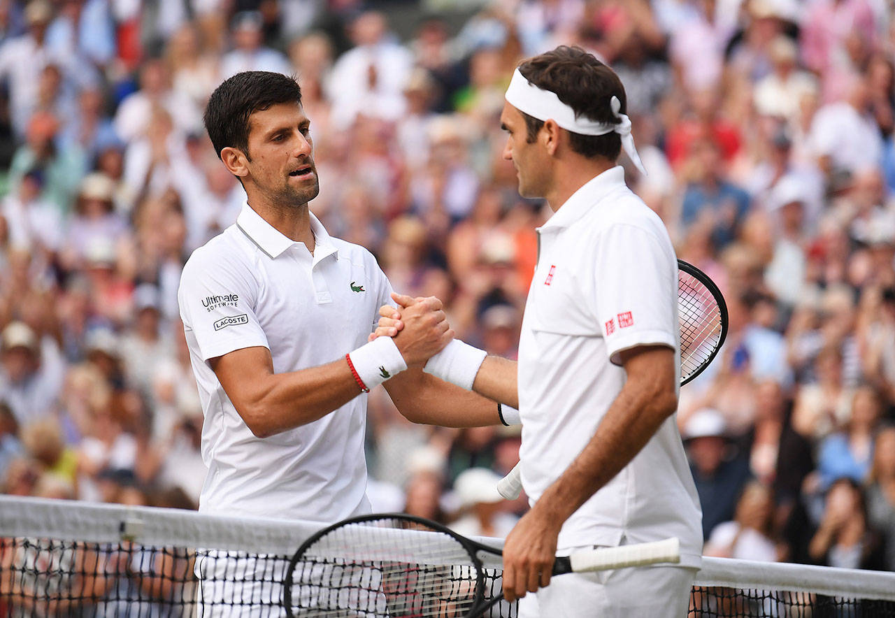 Novak Djokovic, left, and Roger Federer following the men’s singles final on day 13 of the Wimbledon Championships at the All England Lawn Tennis and Croquet Club, Wimbledon on Sunday, July 14, 2019 in London, England. Djokovic defeated Roger Federer 7-6, 1-6, 7-6, 4-6, 13-12 to win his fifth Wimbledon championship. (Laurence Griffiths/PA Wire/Zuma Press/TNS)