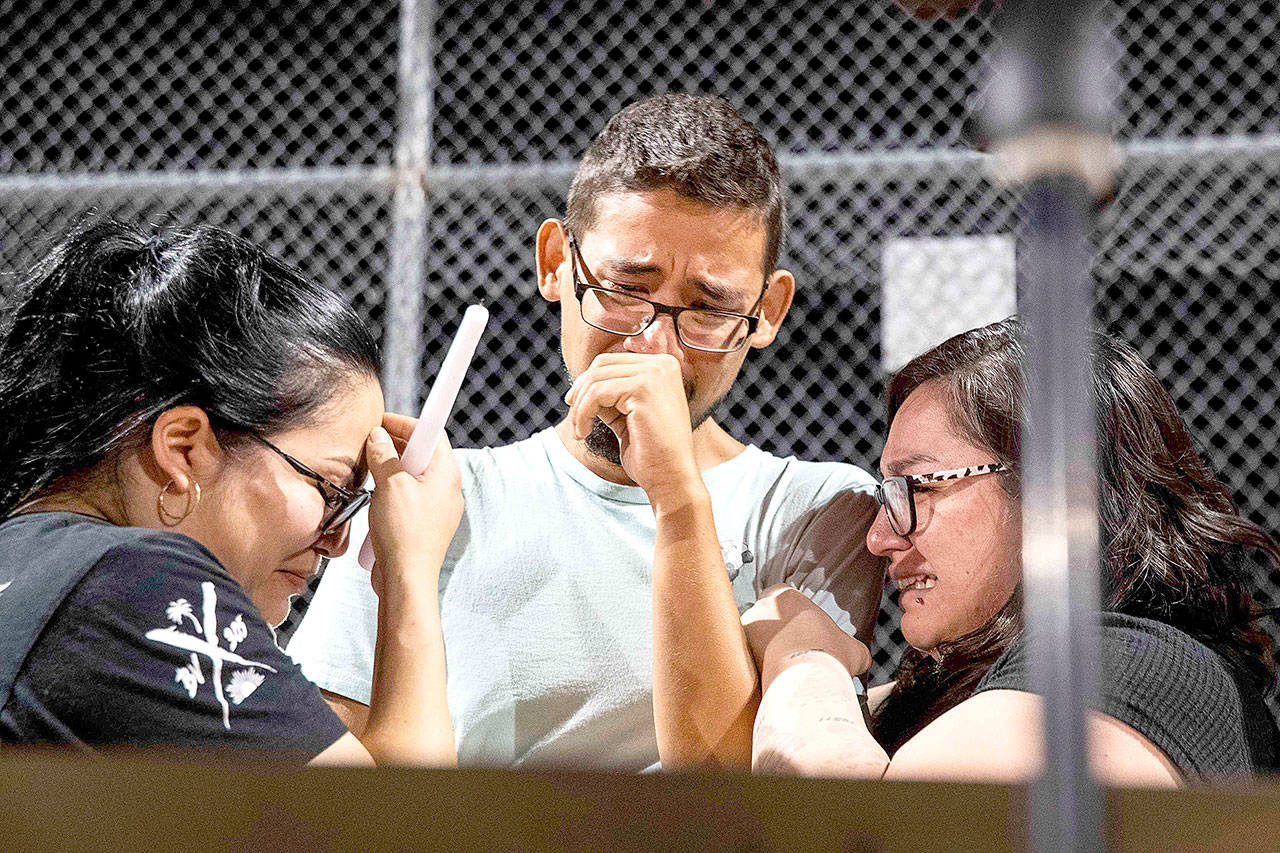 Three of the Walmart workers — Melisa Gonzalez, Jesus Romero and Raven Ramos — who helped people to escape during a mass shooting occurred on Saturday, get emotional during during a vigil at Ponder Park in honor to the victims in El Paso on Sunday. [Lola Gomez / Austin American-Statesman)